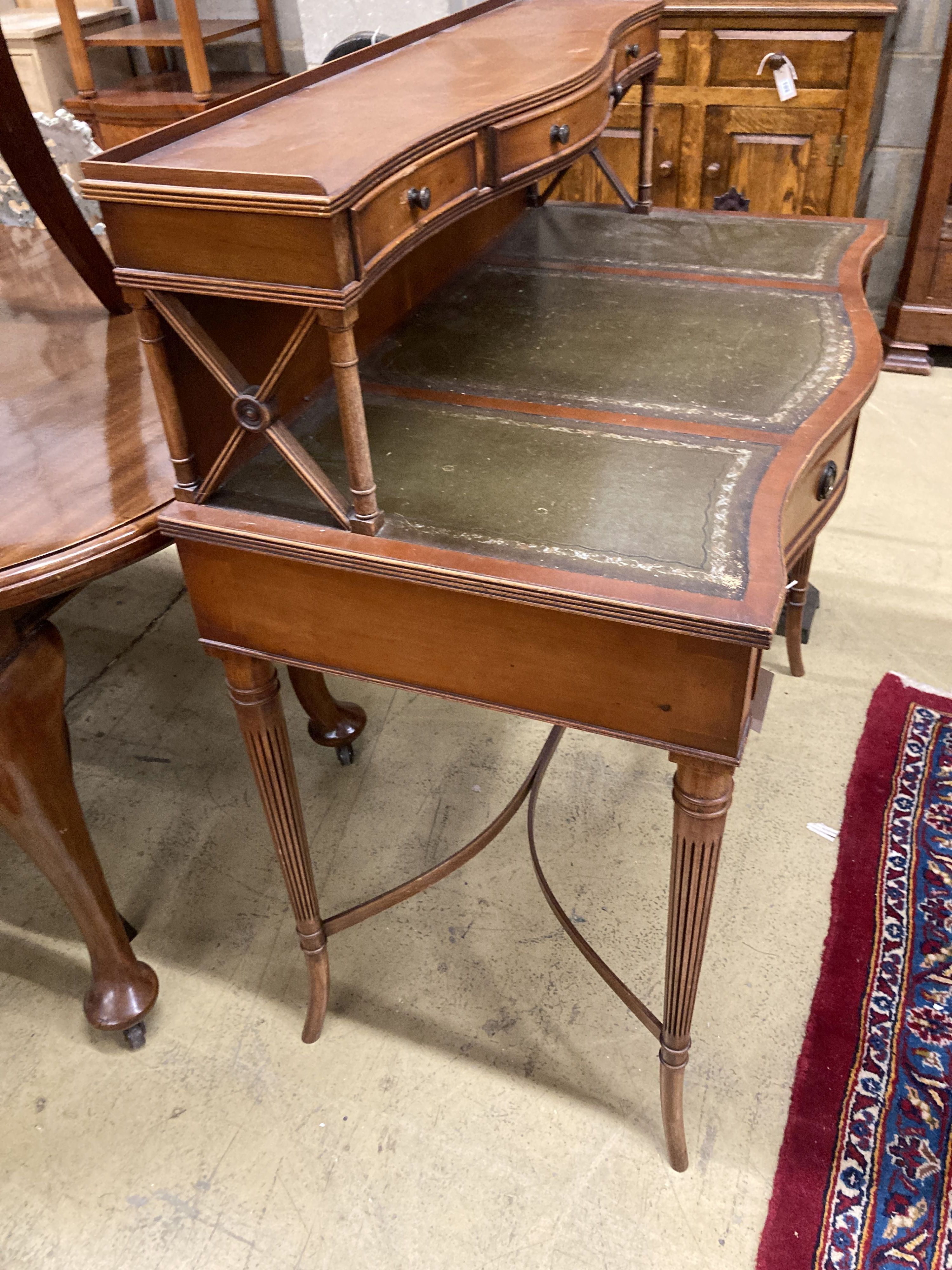 A reproduction yew serpentine writing table, width 92cm, depth 50cm, height 103cm